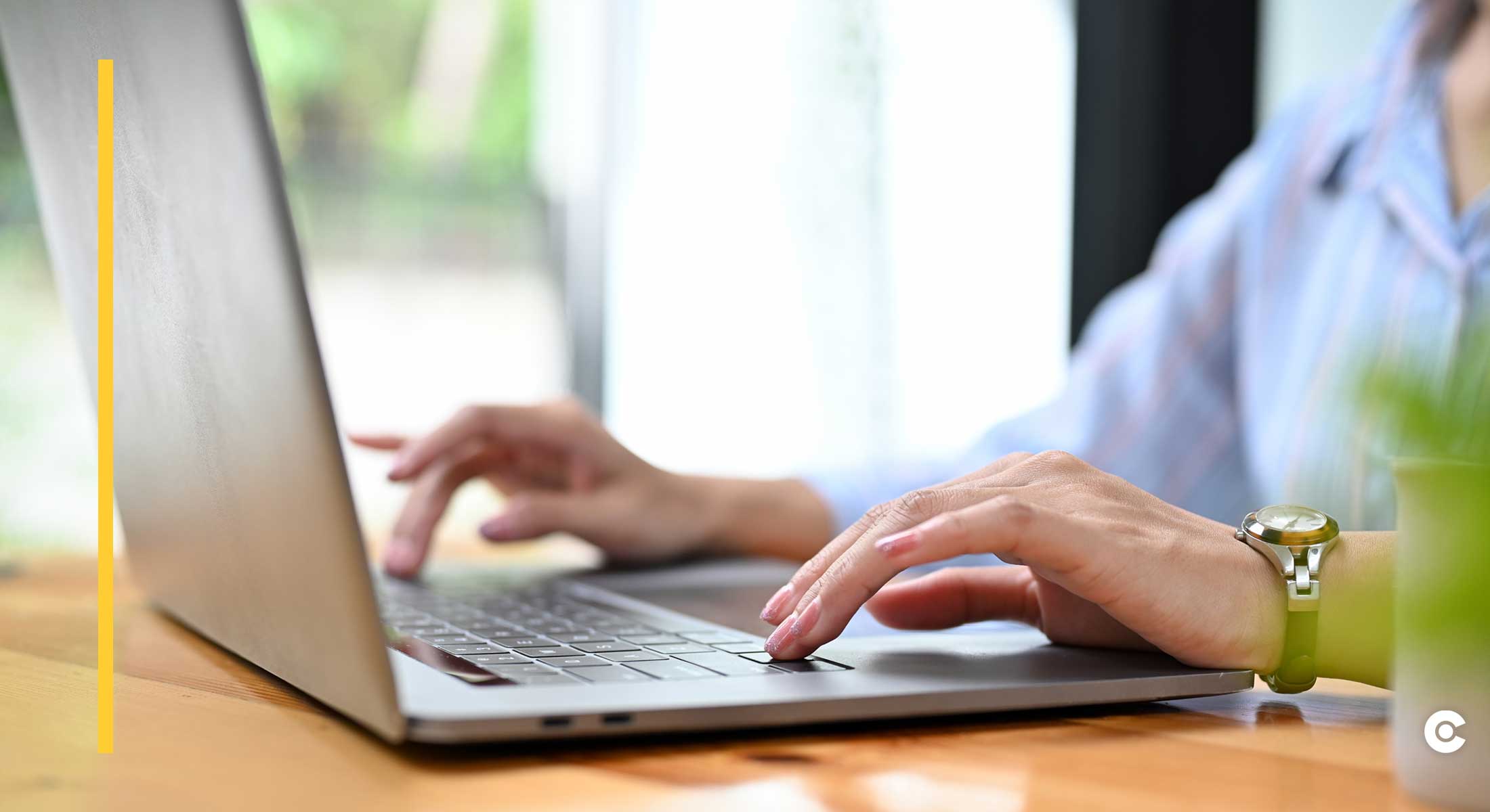 A woman types on a laptop keyboard