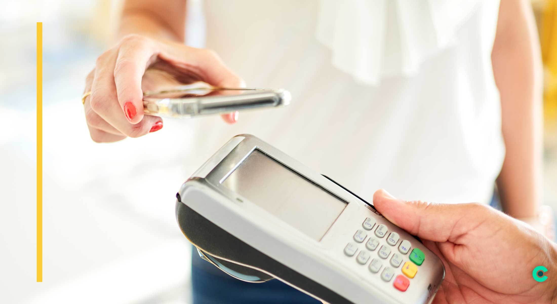 A woman holds her mobile phone over a payment terminal