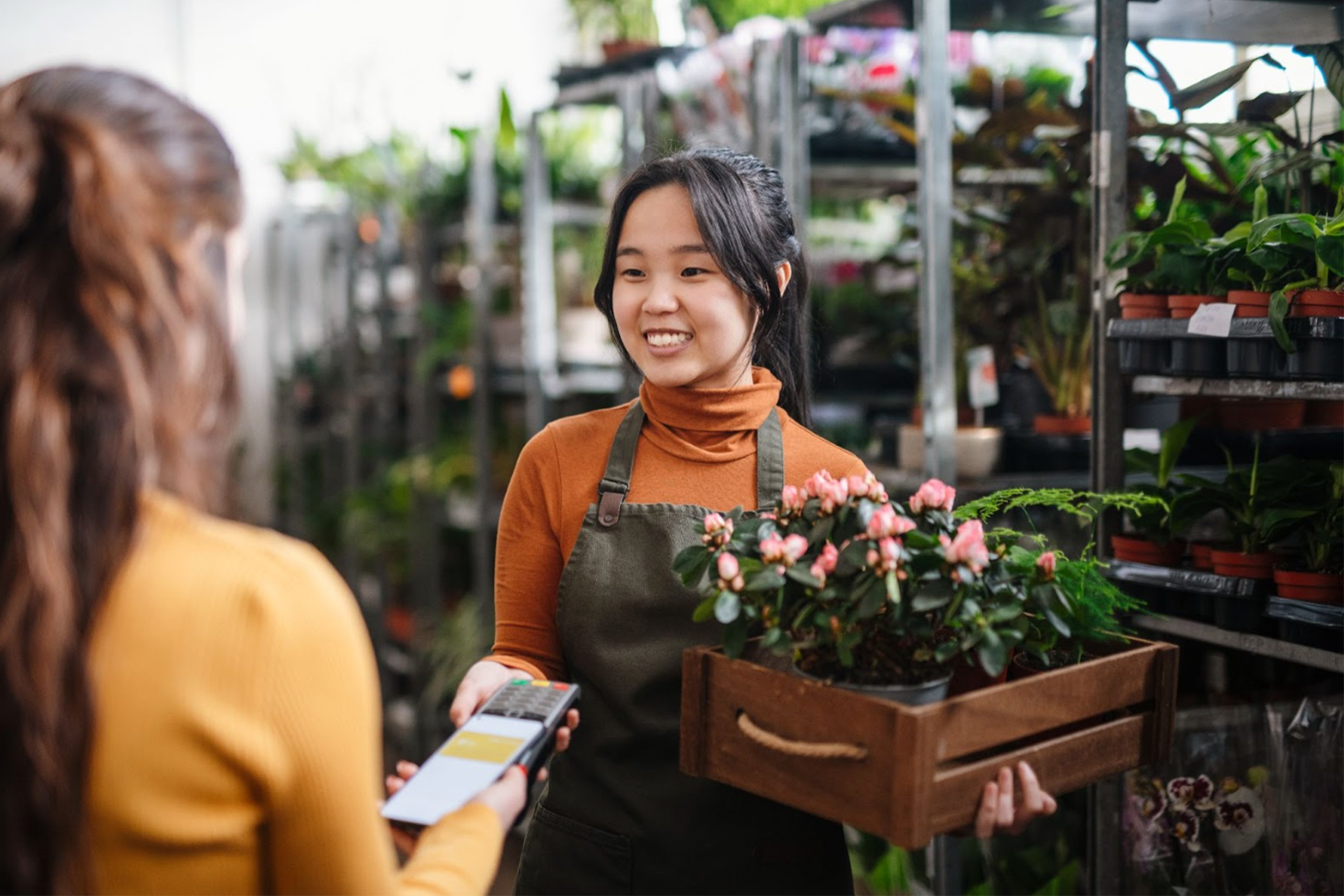 A florist is processing a card payment for flowers.